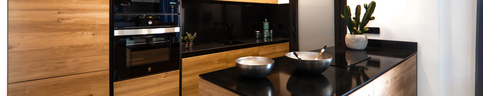 full kitchen remodel with wood grain cabinets, black countertops